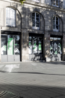 Façade d’un bar du centre historique de Nantes avec trois grandes fresques illustrées par Yollema sur les vitrines.