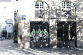 Façade d’un bar du centre historique de Nantes avec deux fresques illustrées par Yollema sur les vitrines.