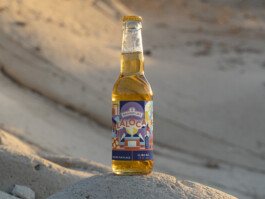 Bouteille de bière Lalôca posée sur un caillou, avec une étiquette réalisée par Yollema pour Les 3 Brasseurs Labège. 