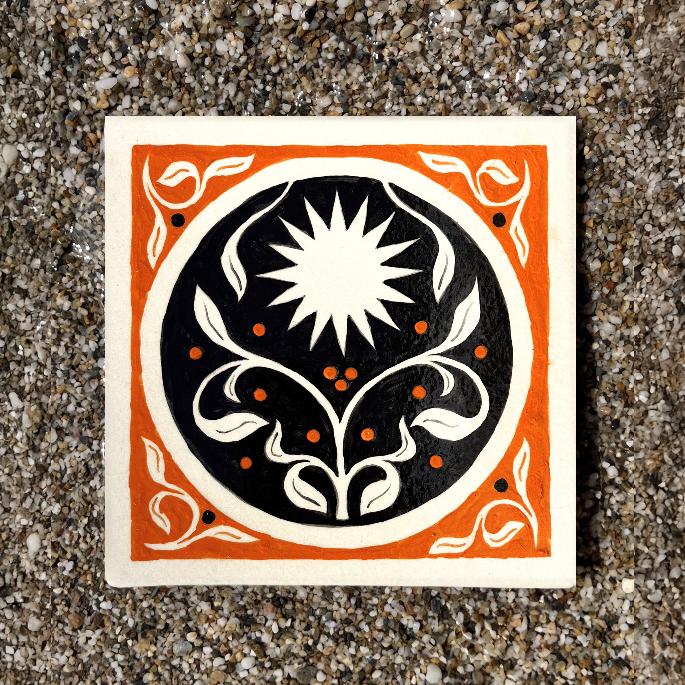 Carreau en grès peint à la main avec un soleil et un motif floral sur fond orange et noir par Yollema
