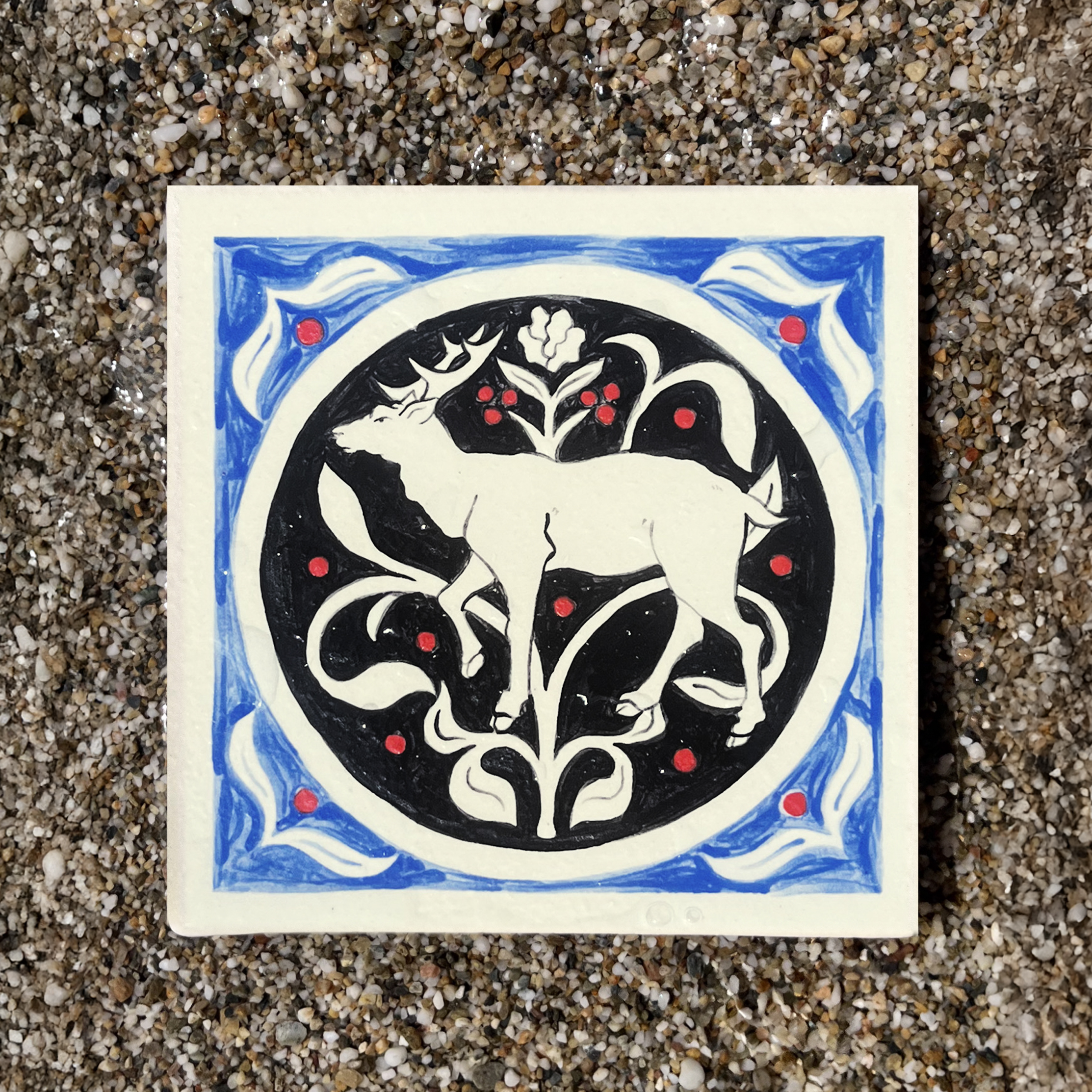Carreau en grès illustré avec un cerf et un motif floral bleu et noir par Yollema
