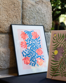 Illustration A3 en risographie par Yollema, encadrée et appuyée contre un mur en pierre