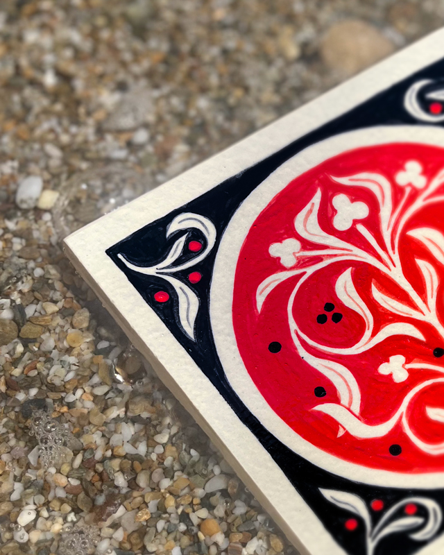 Détail d'un carreaux de grès rouge et noir peint à la main avec une illustration florale par Yollema