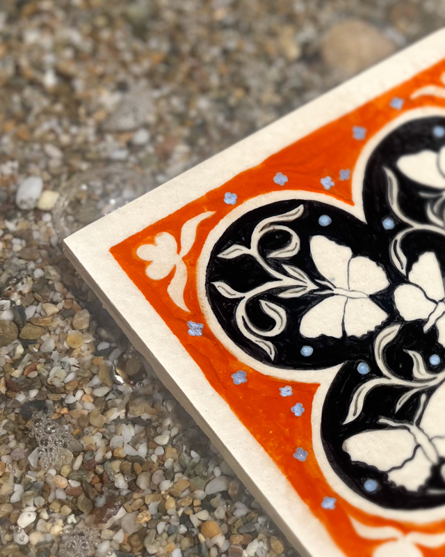 Détail d'un carreaux de grès orange et noir peint à la main avec des papillons par Yollema