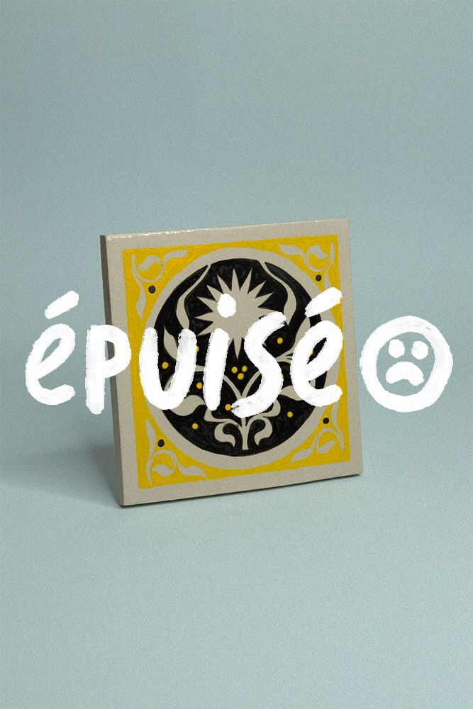 Carreau de grès décoratif, jaune et noir avec un soleil et un motif floral symétrique avec la mention épuisé.