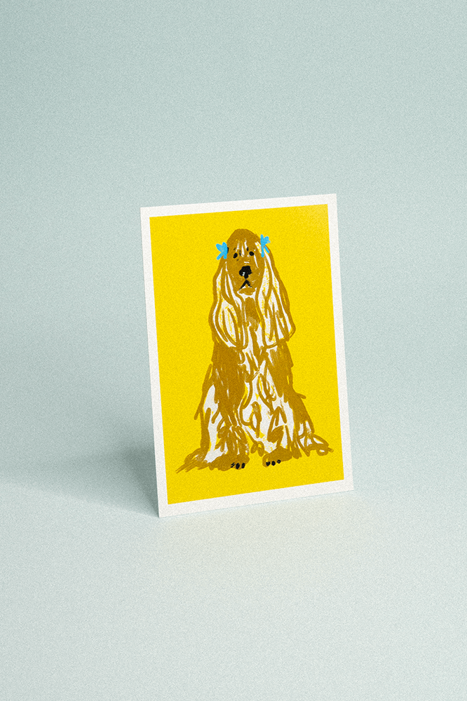 Carte postale fond jaune vif illustrée d’un cocker spaniel assis sagement.