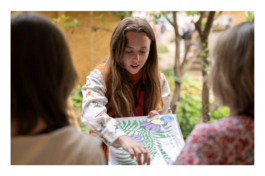 L'artiste Yollema en train de montrer un risographie à des visiteurs pendant un marché de créateurs