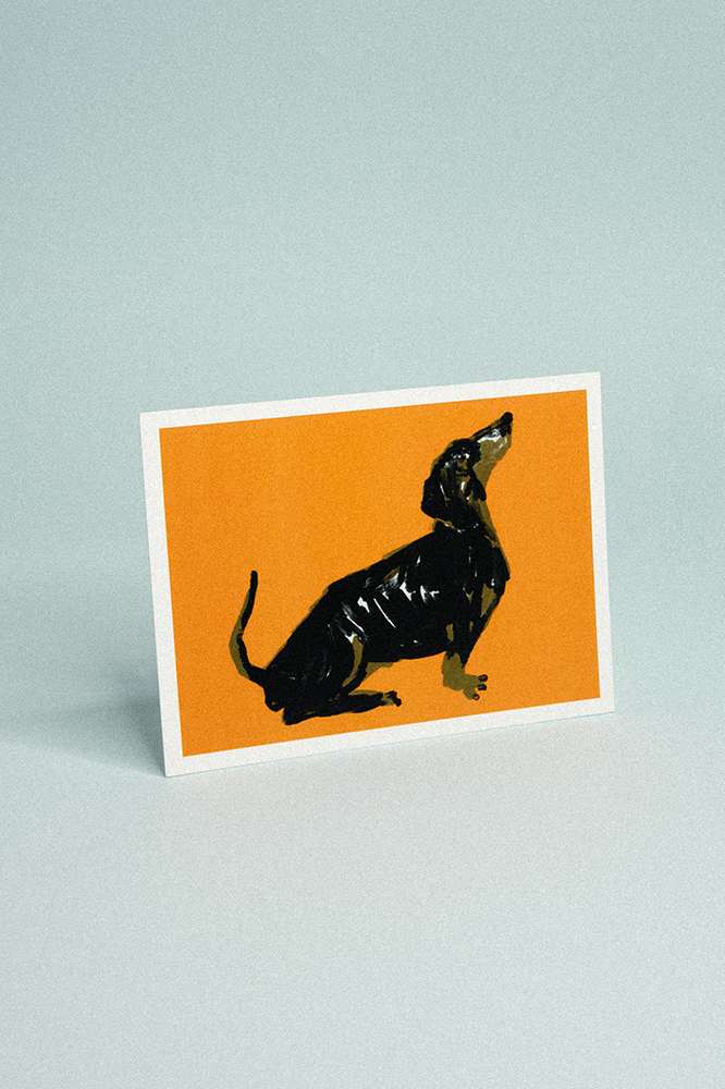 Carte postale fond orange illustrée d’un teckel assis de profil stylisé.