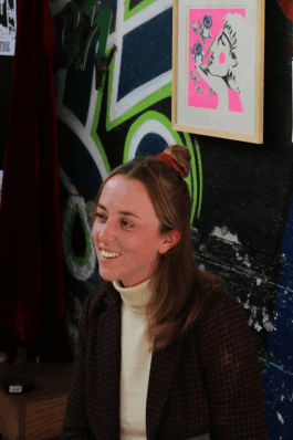 Portrait de l’illustratrice au marché de créateurs du Hasard Ludique à Paris, souriante